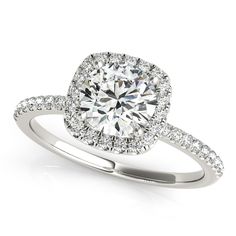 a diamond engagement ring with an oval halo setting and pave set diamonds around the band