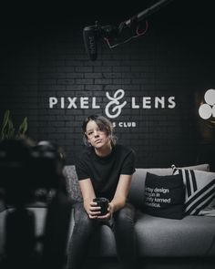 a woman sitting on top of a couch next to a camera