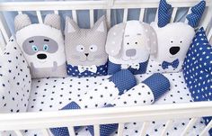 a baby crib with blue and white bedding in the shape of dogs, cats and stars