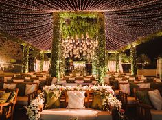 an outdoor wedding venue decorated with flowers and greenery, surrounded by candles and chandeliers