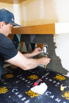 a man is fixing some kind of wallpaper in a room that's under construction