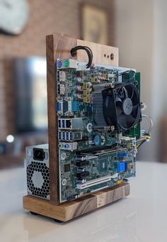 a computer motherboard sitting on top of a white table with a clock in the background