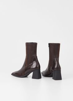 Hedda boots stand out for their elegant minimalist design, making them a sophisticated and versatile option for any occasion.

 Crafted from dark brown leather combined with faux leather, these boots feature a mid-height stretch shaft that hugs the leg perfectly, as well as a square toe that adds a contemporary touch.

 The zipper on the inside of the shaft makes it easy to wear, and the 70 mm high heels provide just the right height to flatter your figure. Brown Stretch Boots, Vagabond Hedda, Clogs Heels, Money Fashion, Stretch Boots, Neutral Shoes, Cream Shoes, Ankle Boots Flat, How To Stretch Boots