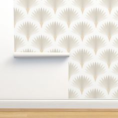 a white wallpaper with an abstract design in the corner next to a wooden floor