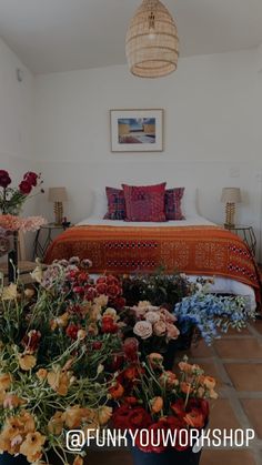 a bed sitting next to a bunch of flowers on top of a tiled floor in a bedroom