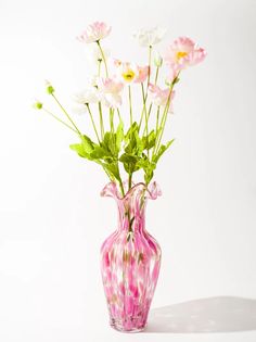 a pink and white vase with flowers in it