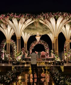 a man standing in front of a stage decorated with flowers