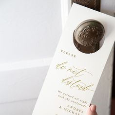 a close up of a person's hand holding a card with a wax stamp on it