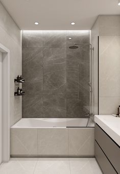 a bathroom with a tub, sink and shower head in the wall next to it