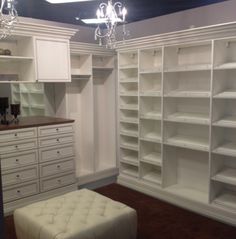 an empty room with white shelving and chandeliers