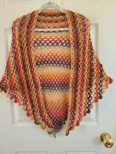 Hand crocheted shawl in V-shape style. Autumn Colors Shawl.  Striped blending of Brown, Tan, Pink and orange.  Drapes well. 64 in. wide from Tip to Tip and 33 in. from nape of neck to to point Acrylic  Machine Wash and Dry  No Iron Crochet Yarn Shawl For Fall, Crochet Shawl For Fall, Crochet Shawl For Fall, One Size, Bohemian Crochet Shawl In Acrylic Yarn, One Size Crochet Shawl For Fall, Brown Crochet Shawl For Fall, Fall Crochet Brown Shawl, Handmade Acrylic Yarn Shawl One Size, Crochet Shawl Patterns With Yarn