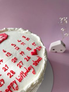 a birthday cake with white frosting and red writing on it