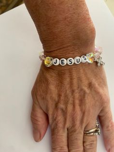 This beautiful Jesus bracelet is made with white alphabet beads( which are acrylic) and a variety of pink and clear ab crystals on 8mm stretchy powecord. And we added a beautiful rhinestone cross. Jesus Bracelet, Themed Bracelets, Alphabet Beads, Rhinestone Cross, Jewelry Bracelets, Alphabet, Beaded Bracelets, Jesus, Bracelet