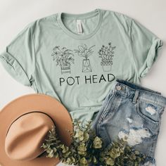 Pot Head T-Shirt - a funny, eye-catching shirt with boho potted plant designs. This cute graphic tee is perfect for the plant lover or gardener with a green thumb. Our T-shirt feels soft and light with just the right amount of stretch. It's pre-shrunk, comfortable and flattering for both men and women. Please note that although the size options in the dropdown box say 'Men's', this is a unisex T-shirt. Refer to the size chart in the photos for measurements. Solid colors are 100% combed and ring-spun cotton. Heather colors are 52% combed and ring-spun cotton and 48% polyester. Heather prism colors are 99% combed and ring-spun cotton and 1% polyester. Care Instructions: Machine wash cold, inside-out, gentle cycle with mild detergent and similar colors. Use non-chlorine bleach, only when nece Green Graphic Print T-shirt For Gardening, Cotton Graphic Print T-shirt For Gardening, Cotton T-shirt With Graphic Print For Gardening, Crew Neck Cotton T-shirt With Plant Details, Cotton Crew Neck T-shirt With Plant Details, Spring Relaxed Fit T-shirt With Plant Details, Cotton Crew Neck T-shirt With Plants, Casual Relaxed Fit T-shirt With Plants, Green T-shirt With Plants Print, Relaxed Fit