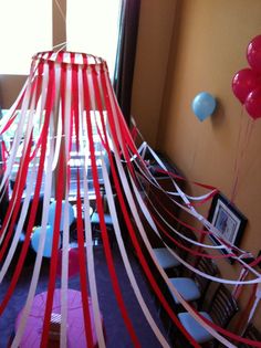 red, white and blue streamers are hanging from the ceiling in this party room