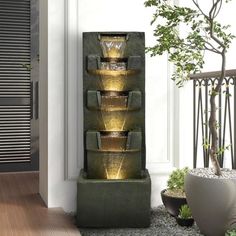 a water fountain in the corner of a room next to a potted plant and door