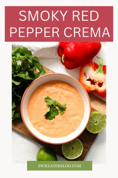 a bowl of smoky red pepper crema with limes and peppers on the side