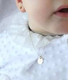 a close up of a child wearing a white shirt with a necklace on it's neck