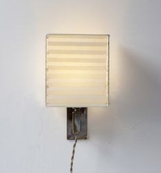 a light that is on the wall with a cord attached to it's side