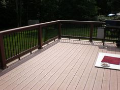 a deck with grill and rug on it