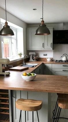 a kitchen with two stools at the island