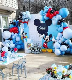 a mickey mouse balloon arch is decorated with balloons