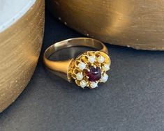 Cabochon Garnet & Seed Pearl Daisy Ring  9ct Gold  Circa 1920's Gorgeous Daisy Style Ring with A Cabochon Garnet Centre & Seed Pearl Petals Makes a Fabulous Pinky Ring  UK Size J US Size 5 Can be resized using our resizing service, please contact us for more information All of our items are either Antique, Vintage or Preloved. They are in used condition & may show some signs of age related wear, light surface scratches or tarnish.  All of our items have been hand selected by us & carefully check Vintage Cabochon Ruby Ring Gift, Antique Ruby Cabochon Ring, 14k Gold Red Cabochon Ring, Vintage Brass Cabochon Rings, 14k Gold Red Cabochon Ruby Ring, J Us, Daisy Ring, Antique Boxes, Seed Pearl