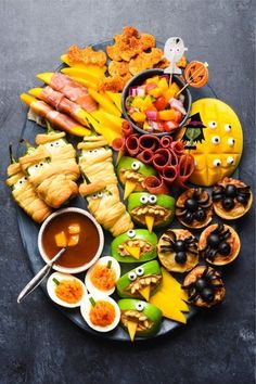 an assortment of food on a platter with eyes drawn on the faces and hands