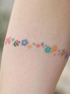 a close up of a person's leg with flowers on it and the word love written in small letters