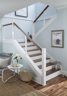 a white staircase with wooden handrails in a living room next to a coffee table