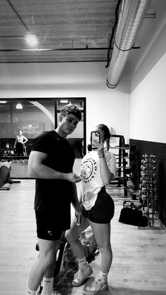 a man and woman taking a selfie in a gym