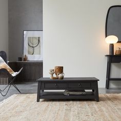 a black coffee table sitting on top of a rug in a living room next to a chair