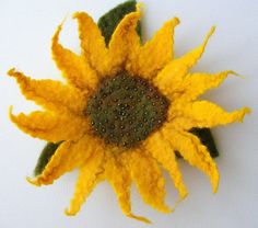 a close up of a yellow flower on a white surface