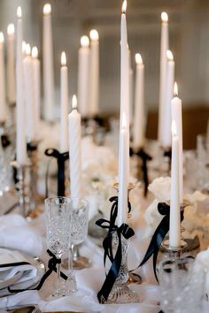 a table topped with lots of white candles