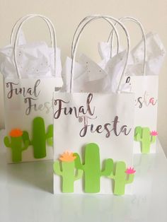 three paper bags with the words final fiesta written on them and cactus decorations in front