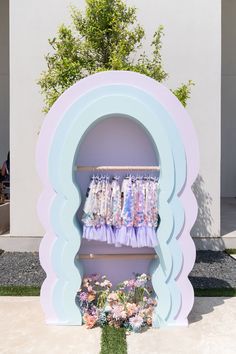 there is a display in the shape of a shelf with clothes on it and flowers