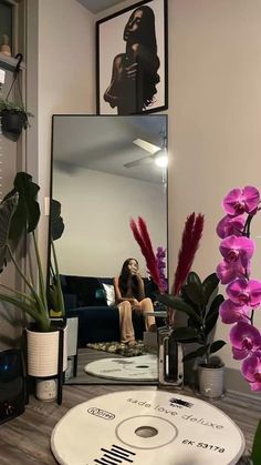 a woman taking a selfie in front of a mirror with flowers on the table