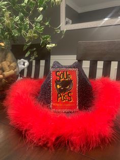 a red furry hat sitting on top of a wooden table