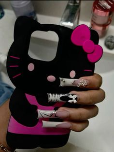 a person holding a hello kitty phone case in their hand with nail polish on it