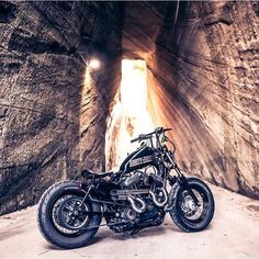 two motorcycles are parked in the middle of a tunnel with light coming through it and there is no one on the bike