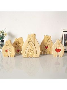 four wooden bears are lined up in a row on a table next to a framed photo