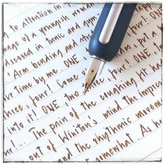 a fountain pen sitting on top of a paper with writing in cursive ink