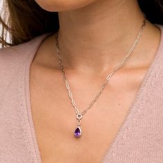 Reach new style heights in this pear-shaped amethyst and white lab-created sapphire frame dangle paper clip necklace - featuring your favorite birthstone. Crafted in sterling silver The faceted 9.0 x 6.0mm pear-shaped bright purple amethyst dangle glistens in a frame of shimmering white lab-created sapphires. A paper clip chain link connects the drop to an open circle, also shining with white lab-created sapphires. Amethyst is the traditional birthstone for February and represents peace and tranquility. This 17.0-inch paper clip chain necklace secures with a lobster claw clasp. Elegant Teardrop Birthstone Drop Necklace, Elegant Pear-shaped Birthstone Drop Necklace, Elegant Lavender Drop Necklaces, Elegant Gemstone Dangle Drop Necklace, Elegant Purple Amethyst Drop Necklace, Elegant Lavender Teardrop Necklace, Elegant Purple Teardrop Pendant Jewelry, Purple Pear-shaped Elegant Jewelry, Elegant Purple Pear Shaped Jewelry