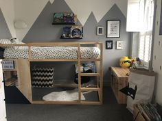 a child's bedroom with a mountain theme on the wall and bunk bed in the corner