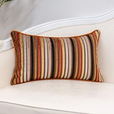 a white chair with a striped pillow on it