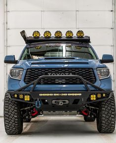 the front end of a blue truck with lights on