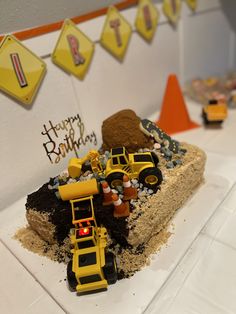 a birthday cake made to look like a construction site with tractors and dirt on it