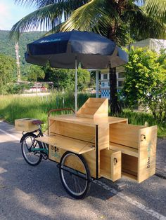 a wooden cart with an umbrella attached to it