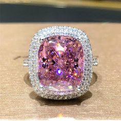 an image of a pink diamond ring with diamonds around it