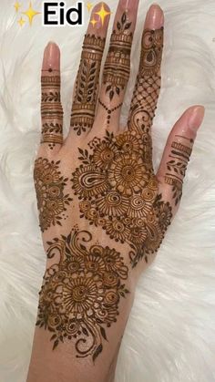 the hand is decorated with henna designs on top of white furnishing and gold stars